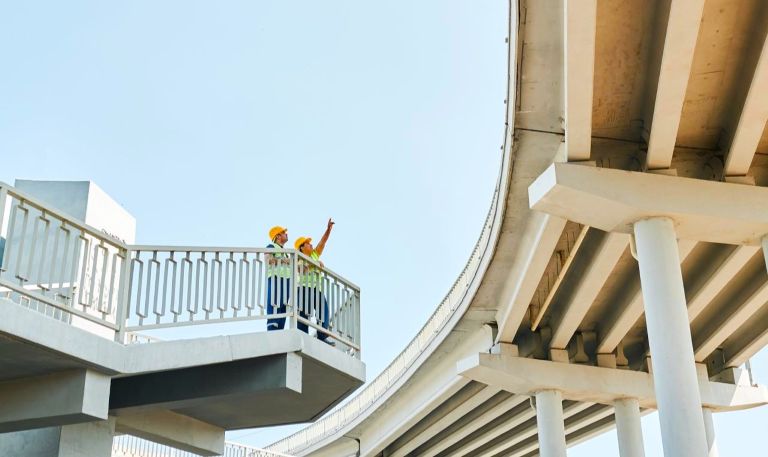 bridge inspectors Workers standing on an elevated access platform beside a concrete bridge, illustrating inspection access and long-term infrastructure maintenance.